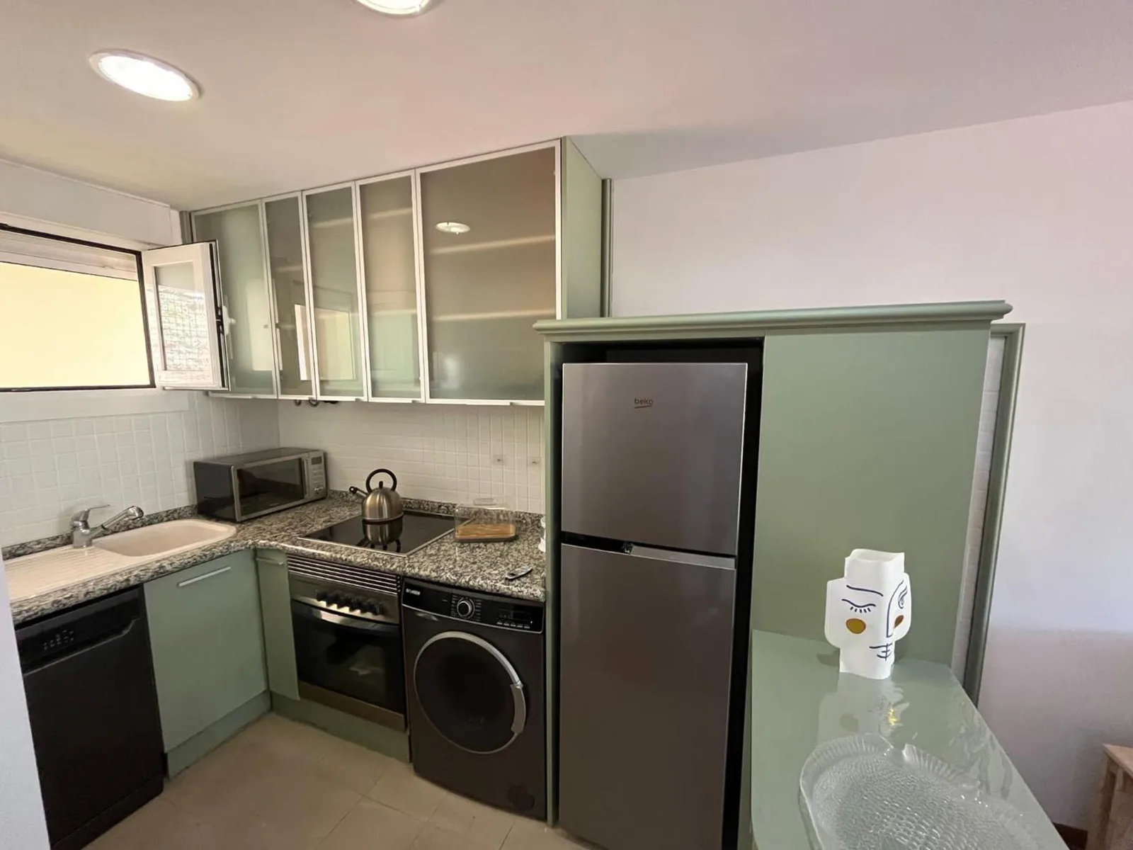 Cocina totalmente equipada del apartamento, con frigorífico y zona de fregadero