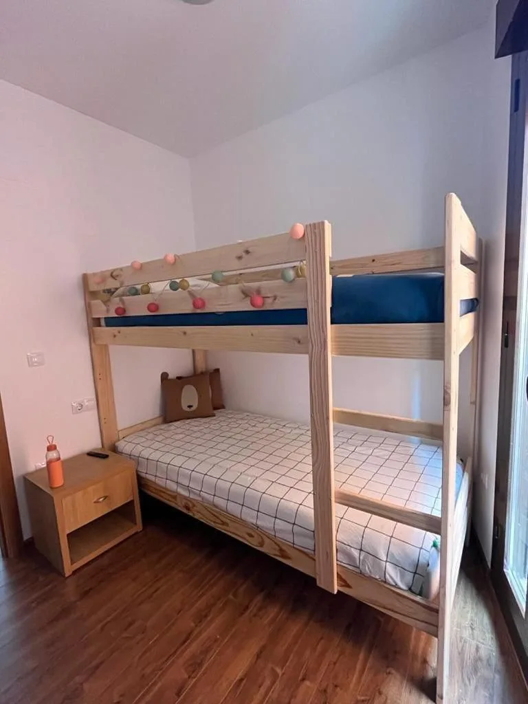 Dormitorio del apartamento con cama doble grande y ventana con vistas a la montaña