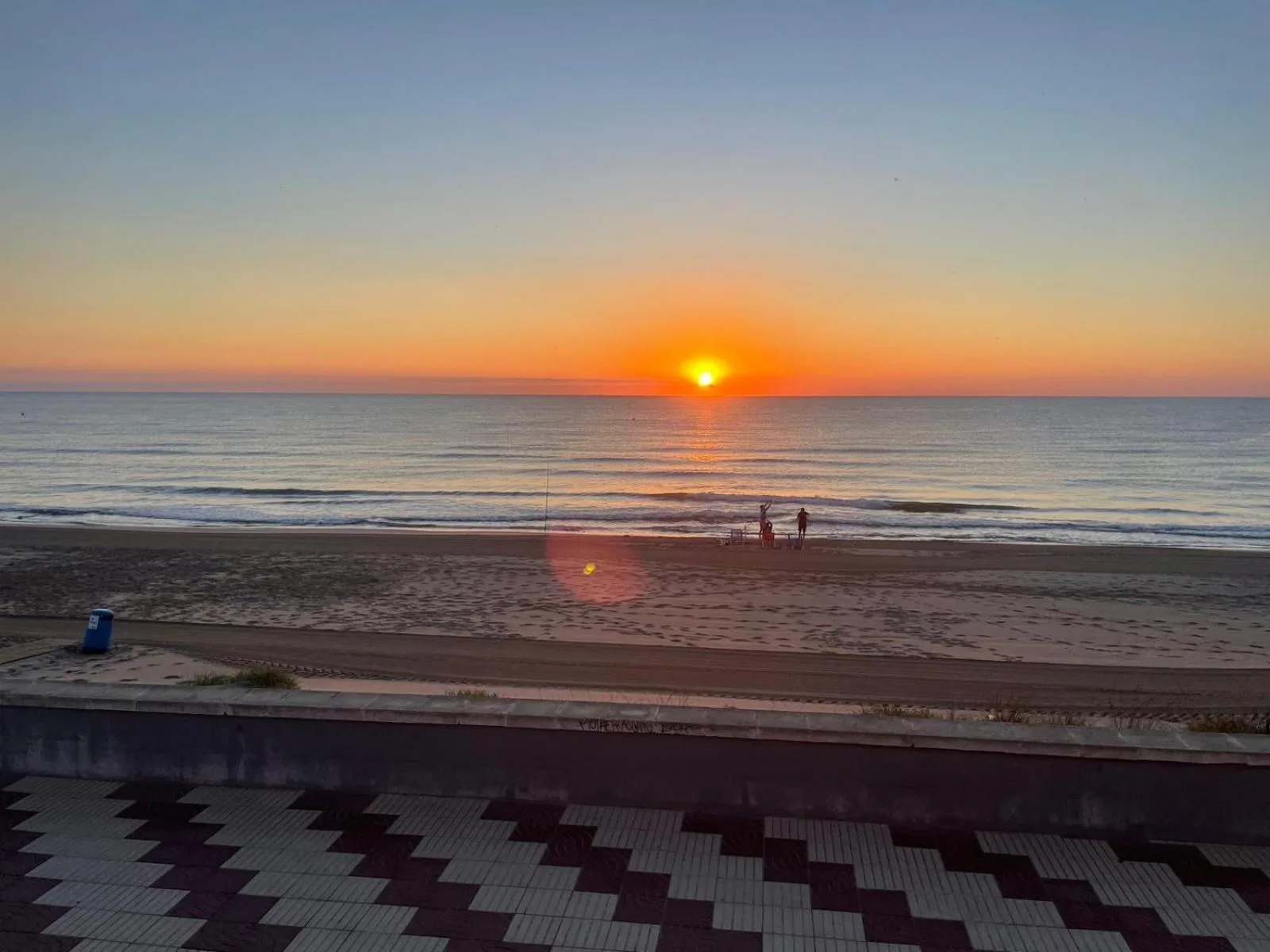 Amanecer sobre el mar en calma frente a la playa de la Llastra, visto desde el apartamento Valencia Frente al Mar