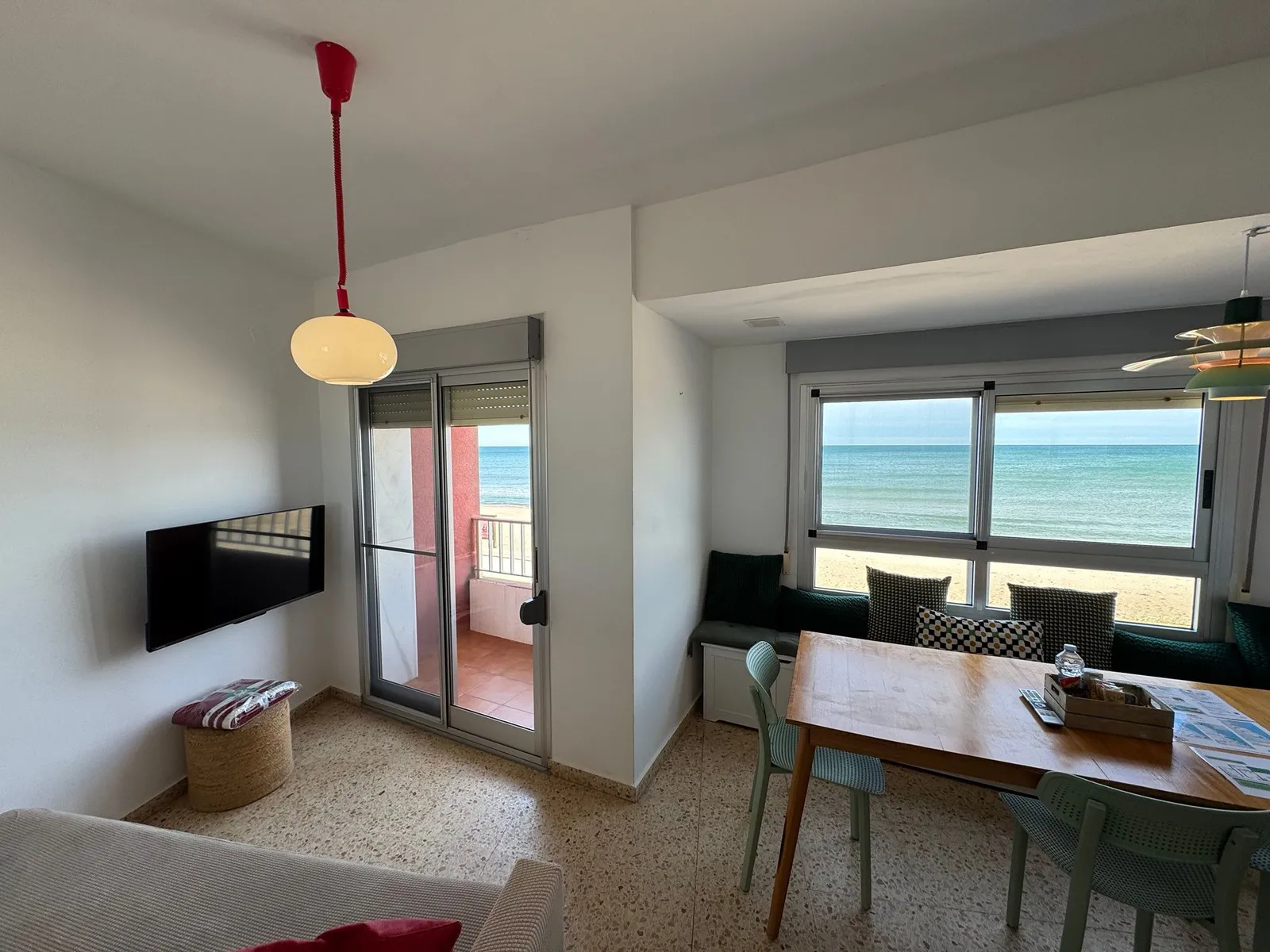 Salón con salida a la terraza y ventanal con vistas frontales al mar y a la arena de la Llastra