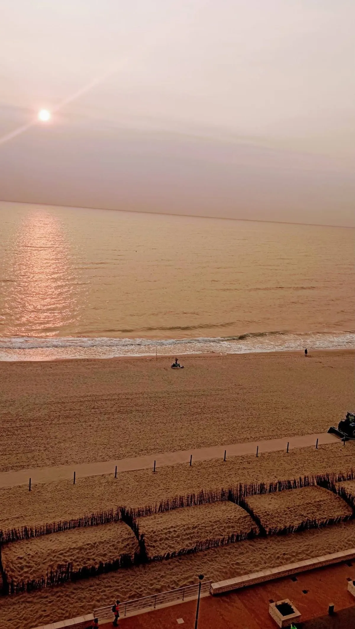 Amanecer brumoso sobre el mar y la playa de la Llastra, visto desde lo alto del apartamento